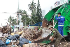 Xe thu gom rác và công nhân vệ sinh môi trường từ thành phố Hồ Chí Minh đến Khánh Hòa hỗ trợ thu gom rác trên bãi biển Nha Trang. (Ảnh: Phan Sáu/TTXVN)