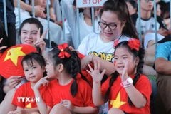 Người dân chờ đón đoàn diễu binh, diễu hành. (Ảnh: Hoàng Hiếu/TTXVN)