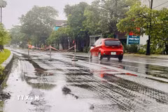 Đoạn đường Quốc lộ 1A đi qua xã Triệu Phong (Quảng Trị) bị sụt lún tạo những vũng nước lớn, tiềm ẩn nguy cơ mất an toàn giao thông. (Ảnh: Nguyên Linh/TTXVN)