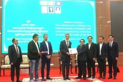 Đại sứ Việt Nam tại Campuchia Nguyễn Minh Vũ (thứ tư, từ trái sang) thực hiện nghi thức bàn giao công trình cho Tổng Thư ký Quốc hội Campuchia Leng Peng Long. (Ảnh: Hoàng Minh/TTXVN)