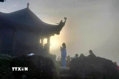 Phật tử "vượt sương, đi xuyên màn đêm" để đón bình minh trên chùa Đồng, nơi đỉnh thiêng Yên Tử, sáng sớm 5/10. (Ảnh: Thanh Vân/TTXVN)