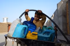 Em nhỏ lấy nước từ vòi nước công cộng ở Kandahar, Afghanistan. (Ảnh: THX/TTXVN)