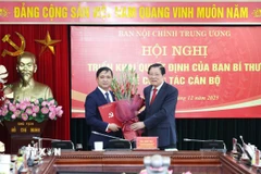 Ông Phan Đình Trạc, Ủy viên Bộ Chính trị, Bí thư Trung ương Đảng, Trưởng Ban Nội chính Trung ương trao Quyết định của Ban Bí thư cho ông Nguyễn Xuân Trường. (Ảnh: Phương Hoa/TTXVN)