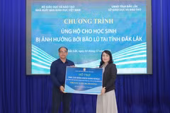 Ông Đặng Thanh Hải, Phó Tổng Giám đốc Nhà Xuất bản Giáo dục Việt Nam, trao biển tặng sách giáo khoa cho bà Võ Thị Minh Duyên, Phó Giám đốc Sở Giáo dục và Đào tạo tỉnh Đắk Lắk. (Nguồn: Vietnam+)