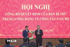 Phó Trưởng Ban Tổ chức Trung ương Nguyễn Quang Dương trao Quyết định và tặng hoa chúc mừng ông Lê Văn Lương. (Ảnh: Xuân Tư/TTXVN)
