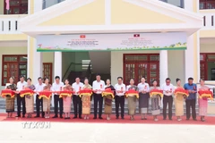 Đại biểu hai nước cắt băng khánh thành Trường Tiểu học và Trung học Hữu nghị cho Hội người Việt Nam tỉnh Salavan. (Ảnh: Xuân Tú/TTXVN)