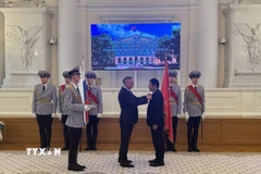 Thống đốc A.Beglov gắn huy hiệu danh dự cho ông Nguyễn Quốc Hùng. (Ảnh: Tâm Hằng/TTXVN)