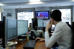Giao dịch viên tại sàn chứng khoán ở Paris, Pháp. (Ảnh: AFP/TTXVN)