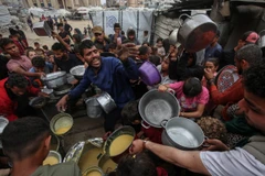 Người dân Palestine nhận thức ăn cứu trợ tại thành phố Gaza ngày 12/5/2025. (Ảnh: THX/TTXVN)