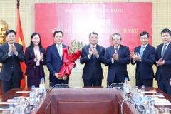 Các đồng chí lãnh đạo Ban Tổ chức Trung ương tặng hoa chúc mừng ông Trịnh Mạnh Linh. (Ảnh: Phương Hoa/TTXVN)