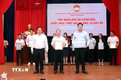 Đại diện Ủy ban Mặt trận Tổ quốc Việt Nam Thành phố Hồ Chí Minh và Ban Vận động Cứu trợ Thành phố Hồ Chí Minh tiếp nhận sự ủng hộ, trao thư cảm ơn các doanh nghiệp ủng hộ đồng bào khắc phục hậu quả thiên tai. (Ảnh: Xuân Khu/TTXVN)