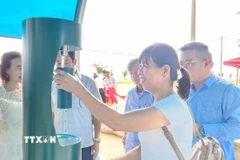 Du khách trải nghiệm trạm nhà chờ và máy cấp nước uống miễn phí. (Ảnh: Mai Trang/TTXVN)