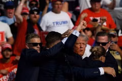Ông Donald Trump được mật vụ Mỹ hộ tống rời khỏi bục diễn thuyết trong cuộc vận động tranh cử ở thành phố Butler, bang Pennsylvania sau khi xảy ra vụ nổ súng, ngày 13/7/2024. (Ảnh: Getty Images/TTXVN)