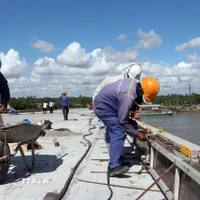 Giữa trưa nắng nóng như đổ lửa, các công nhân vẫn khẩn trương thi công các hạng mục phụ để sớm thông xe kỹ thuật cầu Đại Ngãi 2 dịp lễ 30/4. (Ảnh: Trung Hiếu/TTXVN)