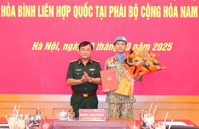 Senior Lieutenant General Hoang Xuan Chien, Deputy Minister of National Defense and Head of the Vietnam Inter-sectoral Working Group on participating in UN peacekeeping operations, presented the Decision to Major Le Vinh Hoang. (Photo: Trong Duc/VNA) ttxvn-trao-quyet-dinh-cua-chu-tich-nuoc-cho-si-quan-di-lam-nhiem-vu-gin-giu-hoa-binh-lien-hop-quoc-8329828-1.jpg