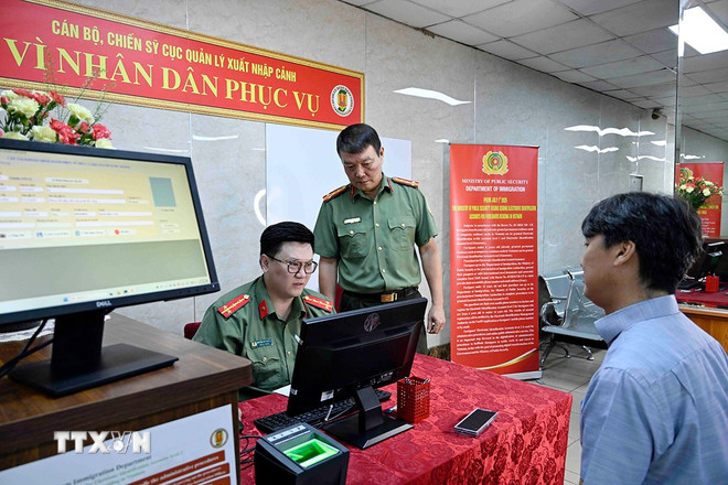 Cán bộ, chiến sỹ Cục quản lý xuất nhập cảnh, Bộ Công an tiếp nhận nhập thông tin người nước ngoài cung cấp vào hệ thống định danh và xác thực điện tử. (Ảnh: Phạm Kiên/TTXVN) ttxvn-dinh-danh-dien-tu-nguoi-nuoc-ngoai-3.jpg