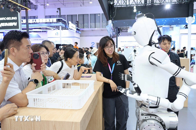 Robot giao lưu với khách tham quan. (Ảnh: Công Tuyên/TTXVN) ttxvn-robot-hinh-nguoi-1.jpg