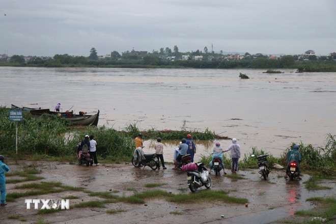 Folk overvåker flom på Tra Khuc-elven i Quang Ngai. (Foto: Pham Cuong/VNA) ttxvn-nuoc-ngap-quang-ngai-3.jpg