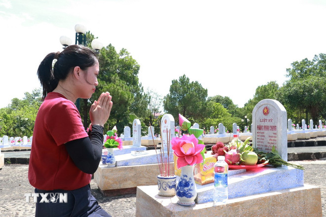 Chị Nguyễn Thị Liên (Hà Nội) viếng và thắp hương tưởng nhớ ông ngoại là liệt sỹ Phùng Minh Chung tại Nghĩa trang Liệt sỹ Quốc gia Đường 9. (Ảnh: Tường Vi/TTXVN) ttxvn-nghia-trang-liet-sy-quang-tri-1.jpg