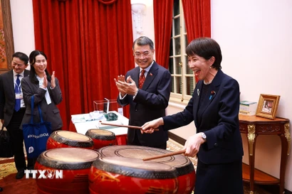 Thủ tướng Nhật Bản Takaichi Sanae trải nghiệm đánh trống - sản phẩm âm nhạc truyền thống của Việt Nam. (Ảnh: Dương Giang/TTXVN)