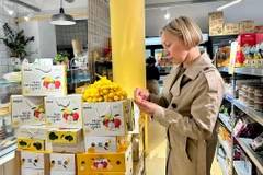 Một khách hàng Pháp nếm thử trái vải thiều đầu tiên của mùa vụ 2025 của Việt Nam. (Ảnh: Nguyễn Thu Hà/TTXVN)