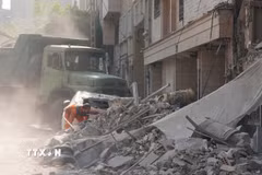 Nhân viên cứu hộ dọn đống đổ nát của tòa nhà bị sập tại Tehran, Iran sau các cuộc không kích của Israel. (Ảnh: THX/TTXVN)