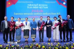 Các đại biểu Việt Nam-Lào chụp ảnh chung tại Lễ bế mạc Tuần phim Việt Nam tại Thủ đô Vientiane. (Ảnh: Đỗ Bá Thành/TTXVN)