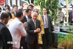 Quốc vương Norodom Sihamoni tham quan các gian hàng trưng bày sản phẩm nông nghiệp, thủ công mỹ nghệ và thành tựu sản xuất nông nghiệp của địa phương. (Ảnh: Quang Anh/TTXVN)