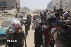 Người dân Palestine nhận hàng viện trợ từ UNRWA tại Dải Gaza. (Ảnh: IRNA/TTXVN)