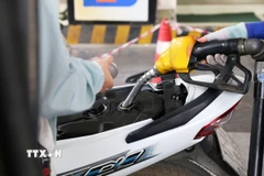 Mua, bán xăng theo giá mới tại điểm kinh doanh xăng dầu Petrolimex trên đường Trần Hưng Đạo, quận Hoàn Kiếm (Hà Nội). (Ảnh: Lê Đông/TTXVN)
