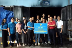 Phó Chủ tịch Liên đoàn Lao động tỉnh Bắc Giang Lê Đức Thọ trao kinh phí hỗ trợ cho doanh nghiệp, người lao động Công ty Cổ phần May Năm Châu. (Ảnh: Đồng Thúy/TTXVN)