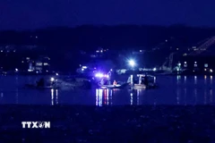Công tác cứu hộ được triển khai tại hiện trường vụ va chạm giữa máy bay chở khách của Hãng hàng không American Airlines với trực thăng BlackHawk của quân đội ở Washington (Mỹ) ngày 30/1/2025. (Ảnh: Reuters/TTXVN)