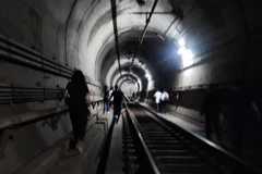 Hành khách di tản khỏi tàu điện ngầm qua một đoạn đường hầm sau khi hỏa hoạn xảy ra hôm 31/5. (Nguồn: Yonhap/The Korea Times)