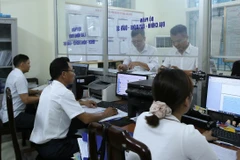 Bộ phận tiếp nhận và trả kết quả phường Trần Hưng Đạo, thành phố Nam Định giải quyết thủ tục hành chính cho người dân. (Ảnh: Công Luật/TTXVN)