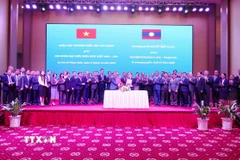 Trưởng đoàn Đại biểu biên giới hai nước Việt Nam-Lào trao đổi biên bản ký kết. (Ảnh: Xuân Tú/TTXVN)