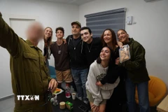 Con tin người Mỹ gốc Israel Edan Alexander (giữa, phía sau) về tới trung tâm đặc biệt ở phía Nam Dải Gaza, sau khi được Phong trào Hamas trả tự do, ngày 12/5/2025. (Ảnh: THX/TTXVN)