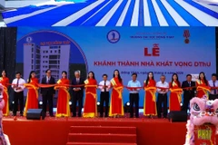 Đại biểu thực hiện nghi thức cắt băng khánh thành Nhà giảng đường và các phòng làm việc bộ môn Trường Đại học Đồng Tháp. (Ảnh: Nhựt An /TTXVN)