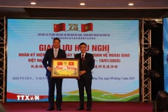 Chủ tịch Hội hữu nghị Việt Nam-Trung Quốc tỉnh Bà Rịa-Vũng Tàu Huỳnh Văn Danh (phải) tặng quà Tổng Lãnh sự Trung Quốc tại Thành phố Hồ Chí Minh Ngụy Hoa Tường. (Ảnh: Đoàn Mạnh Dương/TTXVN)