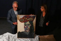 Chuyên gia nghệ thuật Agnes Sevestre-Barbe (phải) và nhà đấu giá Christophe Lucien trưng bày bức tranh "Bust of a Woman with a Flowered Hat" tại Paris, ngày 22/10/2025. (Nguồn: AP/New York Post)