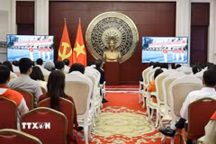 Cán bộ, nhân viên Đại sứ quán và cộng đồng người Việt tại Trung Quốc theo dõi Lễ diễu binh, diễu hành kỷ niệm 80 năm Cách mạng Tháng Tám và Quốc khánh 2/9 qua màn hình nhỏ. (Ảnh: Hải Yến/TTXVN)