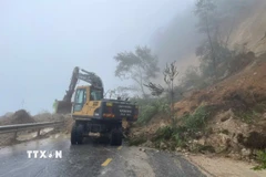 Công ty cổ phần quản lý và xây dựng cầu đường 3 Lai Châu triển khai máy móc, phương tiện để khắc phục sạt lở. (Ảnh: TTXVN phát)