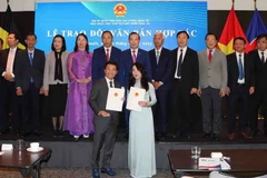 Trao đổi thỏa thuận hợp tác giữa Hội Doanh nghiệp Việt Nam tại Bỉ và Ngân hàng Quân đội (MB). (Ảnh: Hương Giang/TTXVN)