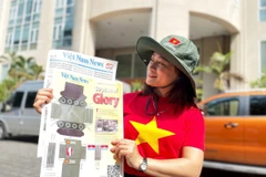 Chị Hoàng Phương (quận 2, Thành phố Hồ Chí Minh) vui mừng sau khi mua ấn phẩm Mô hình cắt dán xe tăng 390 của báo Việt Nam News and Law (Thông tấn xã Việt Nam). (Ảnh: Hồng Đạt)