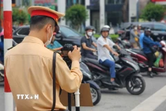 Sử dụng camera lưu động ghi hình hành vi vi phạm là một biện pháp nhằm đảm bảo minh bạch khi phạt nguội, đồng thời tăng tính răn đe đối với người tham gia giao thông. (Ảnh: TTXVN phát)