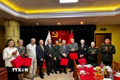 Đại tá, nhà văn Nguyễn Bỉnh Phương, Tổng biên tập Tạp chí Văn nghệ Quân đội, Phó chủ tịch Hội nhà văn Việt Nam (giữa) tặng quà tri ân các nhân chứng lịch sử. (Ảnh: Tâm Hằng/TTXVN)