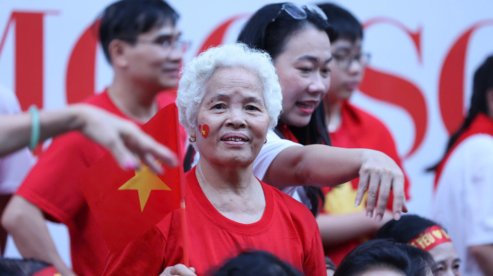 Sắc cờ đỏ sao vàng bắt đầu nhuộm thắm các con phố khi những tia sáng bình minh đầu tiên sắp ló rạng. (Ảnh: PV/Vietnam+)