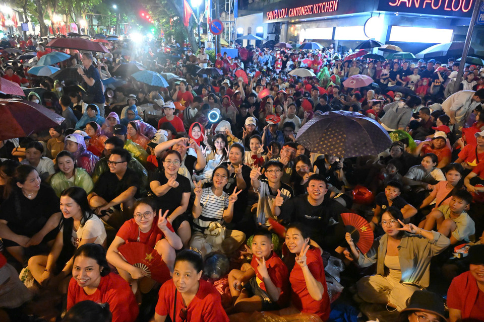 Mưa đã tạnh hẳn, không khí trong lành, se lạnh về đêm không ngăn được dòng người kéo dài dọc các tuyến phố, tạo nên một biển người chờ đón sự kiện trọng đại. Không khí nhộn nhịp, ấm áp tình người. (Ảnh: PV/Vietnam+)