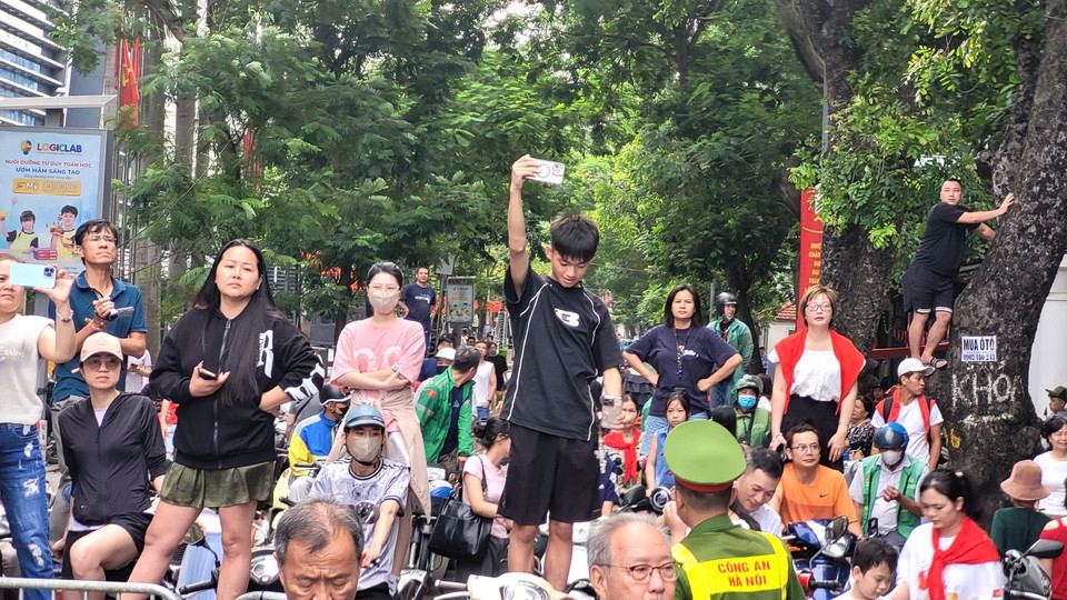 Người dân đa dạng các biện pháp để được tiếp cận được với hình ảnh đoàn diễu binh, diễu hành. (Ảnh: Minh Anh/Vietnam+)