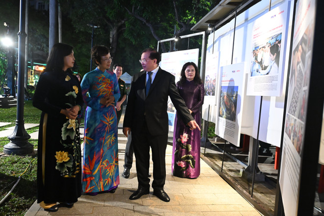 Generaldirektören för Vietnams nyhetsbyrå - Ms. Vu Viet Trang (i blå ao dai) diskuterade tillsammans med biträdande minister för kultur, sport och turism Ta Quang Dong och delegater de utställda verken. (Foto: Minh Anh/Vietnam+) son-3242.jpg