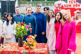 Các sinh viên quốc tế tại Trường Đại học Ngoại thương trong phần thi bày mâm ngũ quả. (Ảnh: PV/Vietnam+)